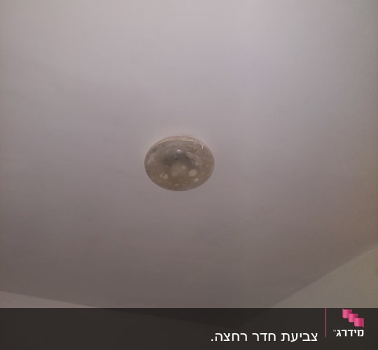 תקרה צבועה בלבן עם מנורה עגולה
